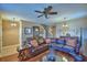 Comfortable living room with hardwood floors, leather sofa, ceiling fan, and elegant decor at 2721 Walden Woods Dr, Plant City, FL 33566