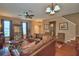 Living room features hardwood floors, ceiling fan, comfortable leather seating, and staircase access at 2721 Walden Woods Dr, Plant City, FL 33566