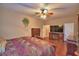 Main bedroom featuring a ceiling fan, dresser, fireplace, and hardwood floors at 2721 Walden Woods Dr, Plant City, FL 33566