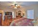 Main bedroom featuring a ceiling fan, dresser, fireplace, and hardwood floors at 2721 Walden Woods Dr, Plant City, FL 33566