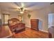 Main bedroom featuring a ceiling fan, dresser, bench, and hardwood floors at 2721 Walden Woods Dr, Plant City, FL 33566