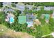 An aerial showcases the community's amenities, including pool, tennis courts, and recreational areas among lush greenery at 34852 Teeview Ln, Zephyrhills, FL 33541