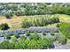 Birds-eye view of townhouses surrounded by lush greenery, trees, parking, and landscaping at 34852 Teeview Ln, Zephyrhills, FL 33541