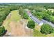 Aerial view of the townhouses with a golf course in the background and treeline surrounding the property at 34852 Teeview Ln, Zephyrhills, FL 33541