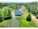 Aerial view of townhouses backing up to a pond, surrounded by lush green trees and shrubbery at 34852 Teeview Ln, Zephyrhills, FL 33541