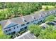 An aerial shows this townhome's setting with nearby parking amidst green spaces, set against the backdrop of a golf course at 34852 Teeview Ln, Zephyrhills, FL 33541