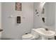 Cozy half bathroom featuring a pedestal sink and religious decorations at 34852 Teeview Ln, Zephyrhills, FL 33541