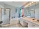 Bright bathroom with a glass shower, bathtub, and white cabinets at 34852 Teeview Ln, Zephyrhills, FL 33541
