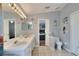 Large bathroom featuring dual sinks, large mirror and access to bedroom at 34852 Teeview Ln, Zephyrhills, FL 33541