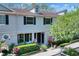 Inviting townhome with dormer windows, black shutters, and lush landscaping, offering curb appeal and style at 34852 Teeview Ln, Zephyrhills, FL 33541