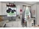 Bright kitchen with granite counters, stainless steel sink, white cabinets, tile floor and hanging pot rack at 34852 Teeview Ln, Zephyrhills, FL 33541