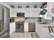 The kitchen is bright with granite counters, stainless appliances, and white cabinets at 34852 Teeview Ln, Zephyrhills, FL 33541