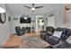 Cozy living room features a plush sectional sofa, ceiling fan, and staircase leading to the second floor at 34852 Teeview Ln, Zephyrhills, FL 33541