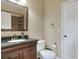 Bathroom features a vanity with dark cabinets, granite counters, a shower with brown tiles, and a toilet at 3507 Autumn Glen Dr, Valrico, FL 33596