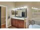 A spacious bathroom includes a double vanity, framed mirror and soaking tub with decorative tile surround at 3507 Autumn Glen Dr, Valrico, FL 33596