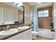 A bathroom features a double vanity, decorative mirror, shower and tub combination at 3507 Autumn Glen Dr, Valrico, FL 33596