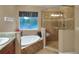 A luxurious bathroom features a soaking tub, glass enclosed shower and decorative tile surround at 3507 Autumn Glen Dr, Valrico, FL 33596