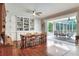 Bright dining area featuring hardwood floors, custom built-ins and a large glass door opening to the lanai and pool at 3507 Autumn Glen Dr, Valrico, FL 33596