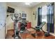 This exercise room features an elliptical, weight bench, and cherry writing desk with views of the outdoors at 3507 Autumn Glen Dr, Valrico, FL 33596