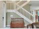 Entryway area with a wooden storage bench beneath a white staircase, and tile flooring at 3507 Autumn Glen Dr, Valrico, FL 33596