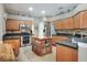 Traditional eat-in kitchen with wood cabinets, black countertops, tile backsplash, stainless appliances, and kitchen island at 3507 Autumn Glen Dr, Valrico, FL 33596