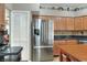 Eat-in kitchen featuring stainless steel appliances, a kitchen island, wood cabinets, and black countertops at 3507 Autumn Glen Dr, Valrico, FL 33596