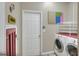 Laundry room boasts modern washer and dryer set, white shelving, and a door to the outside at 3507 Autumn Glen Dr, Valrico, FL 33596