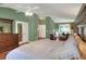 Comfortable main bedroom features hardwood floors, windows with natural light, a ceiling fan, and custom dark wood furniture at 3507 Autumn Glen Dr, Valrico, FL 33596