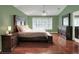 Spacious main bedroom with wood floors features a ceiling fan, ensuite bathroom, and large window at 3507 Autumn Glen Dr, Valrico, FL 33596