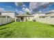 Aerial view of the backyard with a covered patio, privacy fence, and green lawn at 4035 Radiant Mountain Dr, Plant City, FL 33565