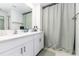 Bright bathroom with a double sink vanity, framed mirror, and a shower with a gray curtain at 4035 Radiant Mountain Dr, Plant City, FL 33565