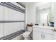Charming bathroom with striped shower curtain, white vanity, and updated fixtures for a modern look at 4035 Radiant Mountain Dr, Plant City, FL 33565