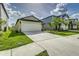 View of the home's exterior showcasing the garage, driveway, and well-manicured lawn at 4035 Radiant Mountain Dr, Plant City, FL 33565