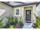 Close up of front door with a decorative wreath and well maintained landscaping at 4035 Radiant Mountain Dr, Plant City, FL 33565