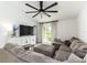 Bright living room boasts a large sectional sofa, tile floors, modern fan, and backyard access at 4035 Radiant Mountain Dr, Plant City, FL 33565
