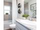 Bright bathroom features a vanity with a marble countertop, framed mirror, decorative shelves, and tub with tiled walls at 7019 161St E Ter, Parrish, FL 34219