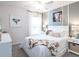 Bright bedroom features a bed with a white headboard, white nightstands, and stylish decor with a cow theme at 7019 161St E Ter, Parrish, FL 34219