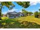 A spacious, green backyard featuring lush landscaping and the rear exterior of the home at 8721 Latham Ln, Hudson, FL 34667
