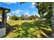Spacious, green backyard with palm trees and a view of the home's screened-in pool area at 8721 Latham Ln, Hudson, FL 34667
