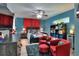 A bedroom with blue walls, red accents, a ceiling fan, and a window with natural light at 8721 Latham Ln, Hudson, FL 34667