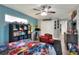 Bedroom featuring gray and blue accent walls, ceiling fan, and a well-lit window with plenty of natural light at 8721 Latham Ln, Hudson, FL 34667