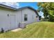 Side view of the home's exterior with a well-maintained lawn and backyard at 8721 Latham Ln, Hudson, FL 34667