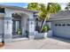 Close-up of the entrance featuring an arched entryway, double doors, and palm trees at 8721 Latham Ln, Hudson, FL 34667