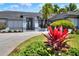 Up-close view of a home's front yard, showcasing lush plants and a well-manicured lawn at 8721 Latham Ln, Hudson, FL 34667
