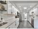 Modern kitchen with white cabinets, quartz counters, and stainless steel appliances at 8721 Latham Ln, Hudson, FL 34667