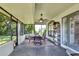 Screened lanai featuring ceiling fan, table and chairs, overlooking the back yard at 8721 Latham Ln, Hudson, FL 34667
