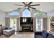Bright living room with vaulted ceilings, fan, fireplace, and many windows at 8721 Latham Ln, Hudson, FL 34667