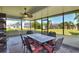 Screened-in patio with ceiling fan and dining set overlooking a lush green lawn at 8721 Latham Ln, Hudson, FL 34667