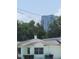 Quaint home with mature trees and a view of a modern building, blending residential charm with city life at 1002 W La Salle St, Tampa, FL 33607