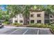 Condo building featuring ample parking and verdant shrubbery along the foundation at 11704 Raintree Village Blvd # B, Temple Terrace, FL 33617